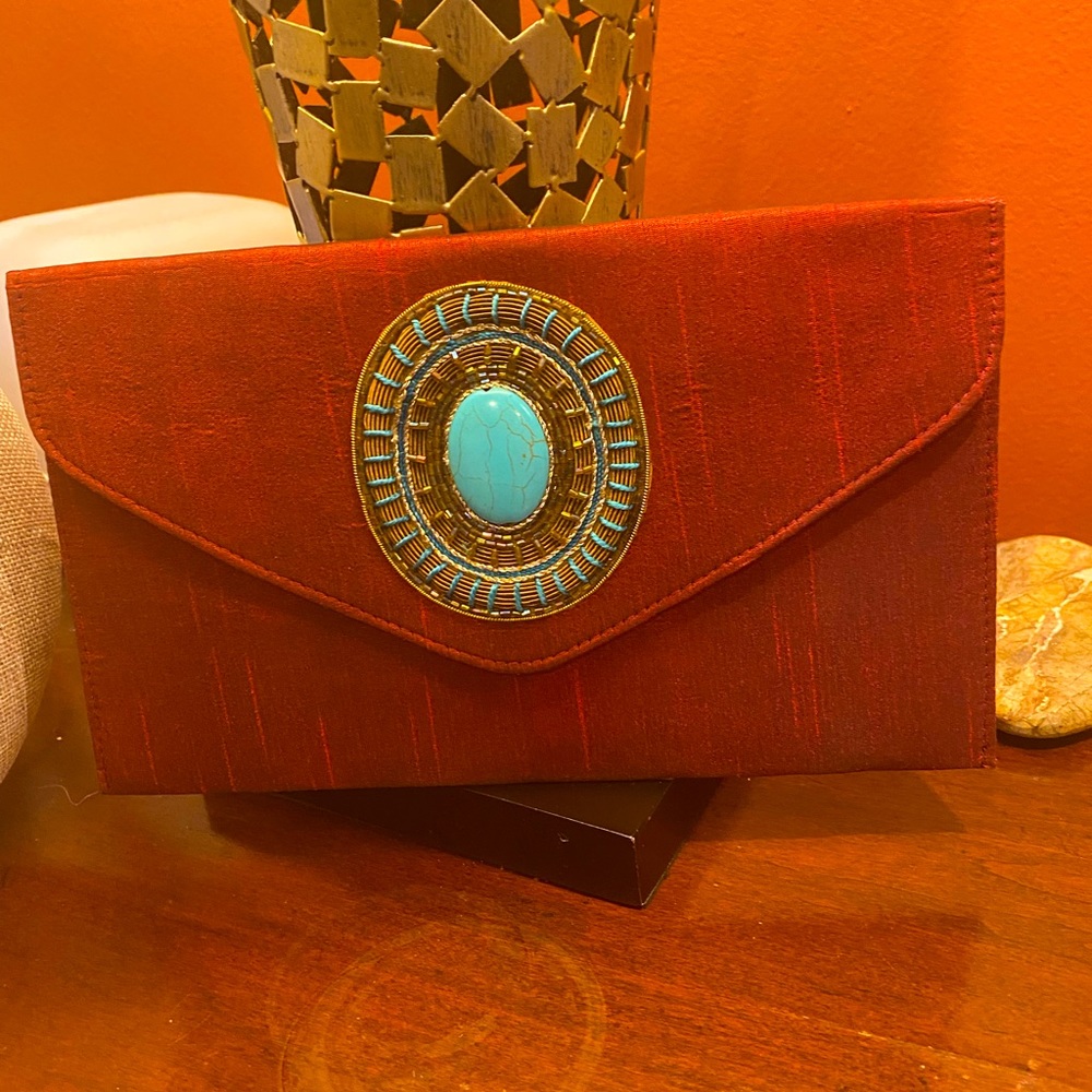 Burgundy iridescent envelope clutch bag with beautiful turquoise detail.